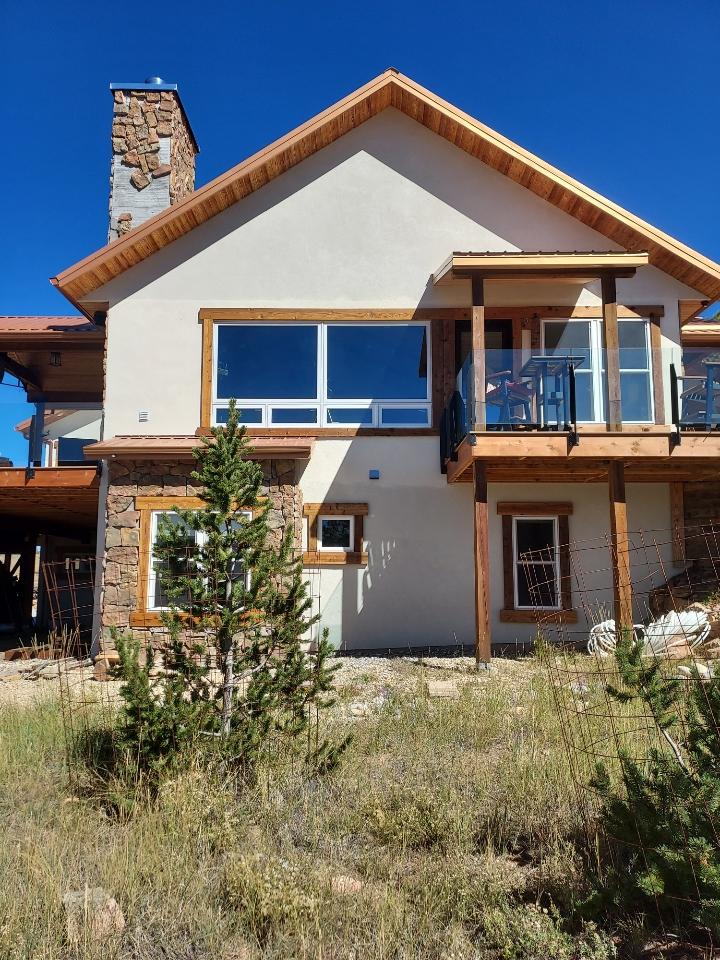 Home exterior with stucco and stone chimney